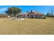 Large backyard with a fire pit seating area, extensive lawn, and a charming brick home in the background at 732 Lindhaven Dr, Pineville, SC 29468