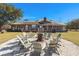 Backyard featuring a fire pit with a seating area surrounded by a spacious lawn and mature trees at 732 Lindhaven Dr, Pineville, SC 29468