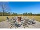 Scenic view of a backyard fire pit encircled by gray Adirondack chairs, perfect for outdoor entertaining at 732 Lindhaven Dr, Pineville, SC 29468