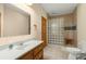 Bright bathroom featuring a glass block shower, single vanity, and neutral tile flooring at 732 Lindhaven Dr, Pineville, SC 29468