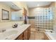 Bathroom showcasing a double vanity, large mirror, and walk-in shower with glass block accent at 732 Lindhaven Dr, Pineville, SC 29468