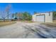 Wide exterior showcasing the shed and equipment storage, with surrounding gravel drive and lush trees at 732 Lindhaven Dr, Pineville, SC 29468