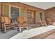 Inviting brick front porch featuring rustic wooden rocking chairs, creating a cozy and relaxing outdoor space at 732 Lindhaven Dr, Pineville, SC 29468