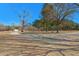 Beautiful land with tall trees and landscaping and a gravel drive, on a sunny day with blue skies at 732 Lindhaven Dr, Pineville, SC 29468