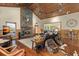 Bright living room displays stone fireplace, wood ceiling, hardwood floors, and open access to kitchen at 732 Lindhaven Dr, Pineville, SC 29468