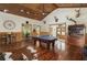 Living room with wood paneling and hardwood floors, accented by rustic decor and a prominent pool table at 732 Lindhaven Dr, Pineville, SC 29468