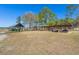 Photo displays open storage shed beside enclosed storage shed, with a vast open field with tall trees at 732 Lindhaven Dr, Pineville, SC 29468