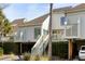 Exterior view of a multi-story home with a staircase leading to a private porch and attached garage at 747 Spinnaker Beachhouse, Seabrook Island, SC 29455