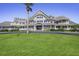 Expansive home featuring multiple balconies, lush green lawn, and stately architectural design at 747 Spinnaker Beachhouse, Seabrook Island, SC 29455