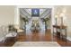 Grand foyer features a dual staircase, hardwood floors, elegant decor, and a beautiful flower arrangement at 747 Spinnaker Beachhouse, Seabrook Island, SC 29455