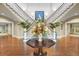 Stunning foyer boasts a dual staircase, beautiful floral centerpiece, and sophisticated decor at 747 Spinnaker Beachhouse, Seabrook Island, SC 29455
