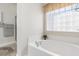 Corner soaking tub and a large glass block window allow natural light at 779 Hamlet Cir, Goose Creek, SC 29445