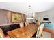 Dining room with wood floors, large wooden table, chandelier, and view into living room at 8 Fairway Oaks Ln, Isle of Palms, SC 29451
