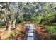 Charming garden featuring a stone walkway, seating area, and lush foliage at 8 Fairway Oaks Ln, Isle of Palms, SC 29451