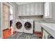 A laundry room with front load washer and dryer, utility sink, and white cabinets for storage at 8 Fairway Oaks Ln, Isle of Palms, SC 29451