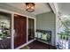 Welcoming front porch with a charming bench and decorative pillows at 8 Fairway Oaks Ln, Isle of Palms, SC 29451