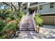 Inviting stairway leads up to a charming home entrance, surrounded by lush landscaping at 8 Fairway Oaks Ln, Isle of Palms, SC 29451