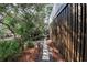 Stone walkway alongside house with privacy fence and lush surrounding greenery at 8 Fairway Oaks Ln, Isle of Palms, SC 29451