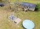 Aerial shot of the backyard, featuring a pool, firepit with chairs and solar panels on the roof at 8072 Bing Hill Road Rd, Adams Run, SC 29426