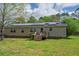 Back of house featuring solar panels on roof, small deck, and a spacious lawn at 8072 Bing Hill Road Rd, Adams Run, SC 29426