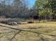 A fenced garden area with raised planting beds and a glimpse of a home in a wooded backyard at 8072 Bing Hill Road Rd, Adams Run, SC 29426