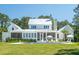 A backyard view showcasing a pool and patio with lounge chairs, set against a white home with a metal roof at 821 Bulls Bay Blvd, Mount Pleasant, SC 29429