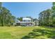 Expansive backyard with a view of a white home featuring a patio, pool, and ample outdoor seating at 821 Bulls Bay Blvd, Mount Pleasant, SC 29429
