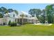 Spacious backyard featuring a white home with a patio, pool, lounge chairs, and lush green lawn at 821 Bulls Bay Blvd, Mount Pleasant, SC 29429