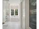 Bright bathroom featuring a standalone soaking tub beneath a chandelier and window with trees outside at 821 Bulls Bay Blvd, Mount Pleasant, SC 29429