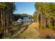 An aerial view of a beautiful white home featuring a spacious lawn, screened porch, and mature trees at 821 Bulls Bay Blvd, Mount Pleasant, SC 29429