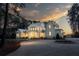 Elegant two-story home at twilight, featuring a circular driveway and professionally landscaped front yard at 821 Bulls Bay Blvd, Mount Pleasant, SC 29429