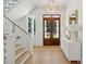 Bright foyer featuring hardwood floors, staircase, entry table, and wooden double doors at 821 Bulls Bay Blvd, Mount Pleasant, SC 29429