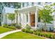 Stunning exterior of a two-story home featuring a covered porch, white columns and lush landscaping at 821 Bulls Bay Blvd, Mount Pleasant, SC 29429