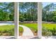 Inviting front view featuring a brick pathway leading to a home framed by lush greenery and stately columns at 821 Bulls Bay Blvd, Mount Pleasant, SC 29429