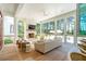 Well-lit screened living room with a white brick fireplace and views of the pool at 821 Bulls Bay Blvd, Mount Pleasant, SC 29429