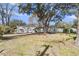 Residential home exterior showcasing a spacious yard with mature trees and grill at 834 Prince John Dr, Charleston, SC 29407