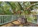 A cozy back porch with wood flooring, a storage chest, and a railing for safety and style at 94 Seaside Cottage Ln, Isle of Palms, SC 29451
