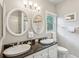 Functional bathroom featuring double sinks, oval mirrors, and a bathtub with a shower at 94 Seaside Cottage Ln, Isle of Palms, SC 29451