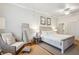 Comfortable bedroom with a full-length mirror, neutral tones, and a view of the ensuite bath at 94 Seaside Cottage Ln, Isle of Palms, SC 29451