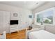 Charming bedroom with hardwood floors, white furniture, and a view of the outdoors at 94 Seaside Cottage Ln, Isle of Palms, SC 29451
