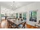 Bright dining room with wood floors and a stylish chandelier leading to an outdoor deck at 94 Seaside Cottage Ln, Isle of Palms, SC 29451