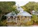 Aerial view showing the house with a metal roof, a porch, and lush greenery all around at 94 Seaside Cottage Ln, Isle of Palms, SC 29451