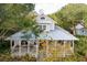 Aerial view of house featuring a metal roof, large porch, and beautiful landscaping at 94 Seaside Cottage Ln, Isle of Palms, SC 29451