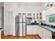 Bright kitchen boasts stainless steel refrigerator, white cabinets, and granite countertops at 94 Seaside Cottage Ln, Isle of Palms, SC 29451