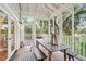Inviting screened porch features a dining table, bench seating, and views of the surrounding landscape at 94 Seaside Cottage Ln, Isle of Palms, SC 29451