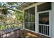 Relaxing screened porch with wood floors and a chest for storage overlooking the yard at 94 Seaside Cottage Ln, Isle of Palms, SC 29451