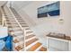 Bright stairway featuring wooden stairs, white railings, and nautical artwork on the wall at 94 Seaside Cottage Ln, Isle of Palms, SC 29451