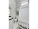 Modest bathroom featuring white tile flooring, a shower-tub combo with curtain, and classic fixtures at 318 Sumter St, Charleston, SC 29403