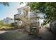 Exterior view of a two-story home with wooden porches and staircases leading to each level at 318 Sumter St, Charleston, SC 29403