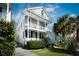 Two-story home with white trim, inviting double porches, and lush landscaping at 318 Sumter St, Charleston, SC 29403